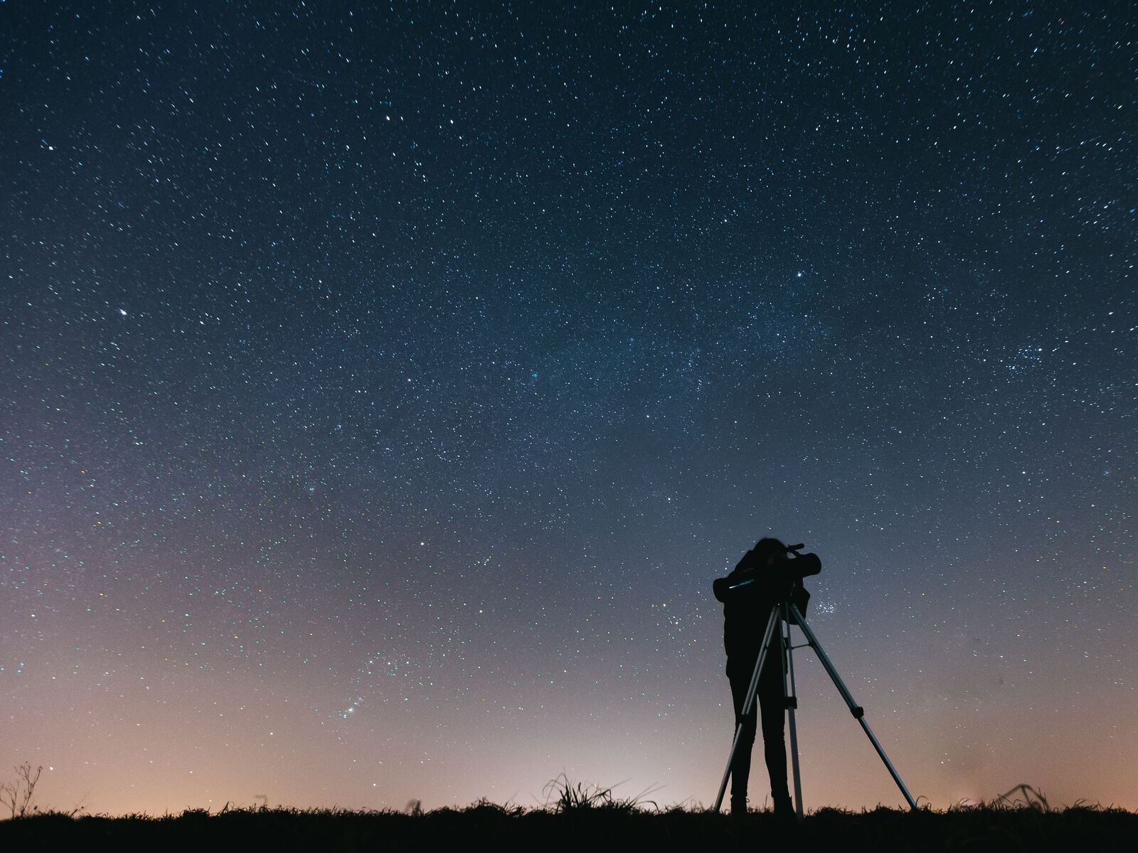 Personne observant le ciel étoilé avec un télescope