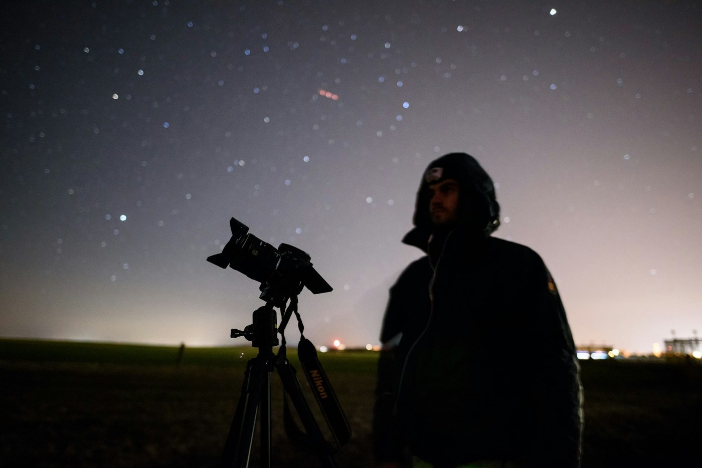Astronome amateur observant le ciel nocturne avec un télescope sur trépied