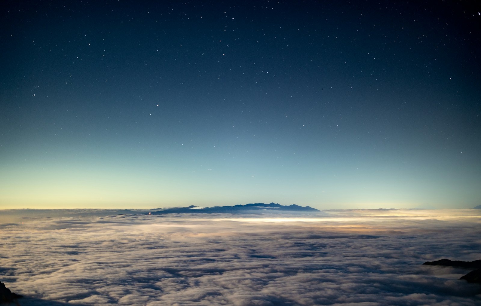 Ciel nocturne étoilé au-dessus d'un relief naturel